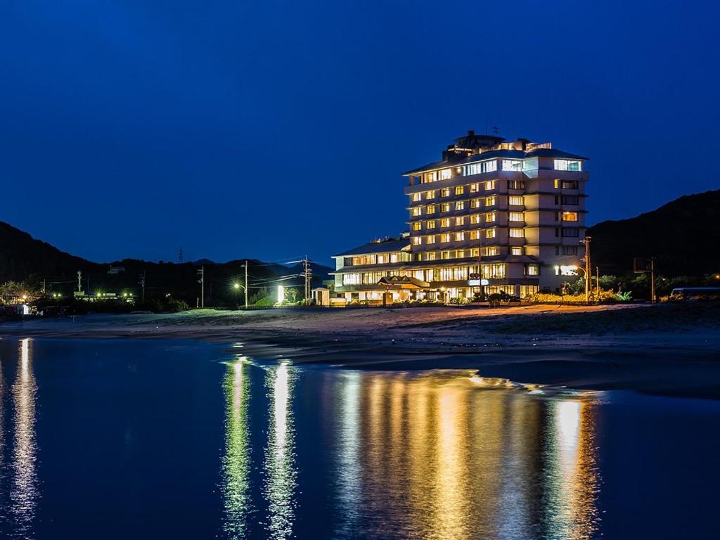 un edificio en la playa por la noche en Naruto Grand Hotel Kaigetsu, en Naruto
