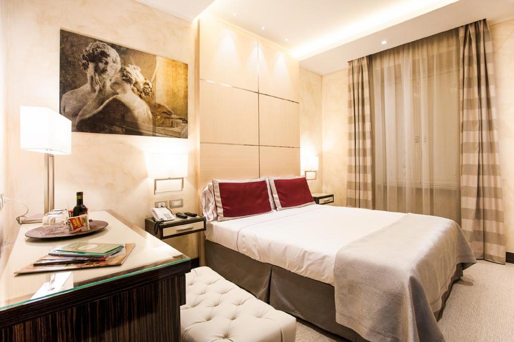 una camera d'albergo con un grande letto e una scrivania di Maison Candia Luxury House a Roma