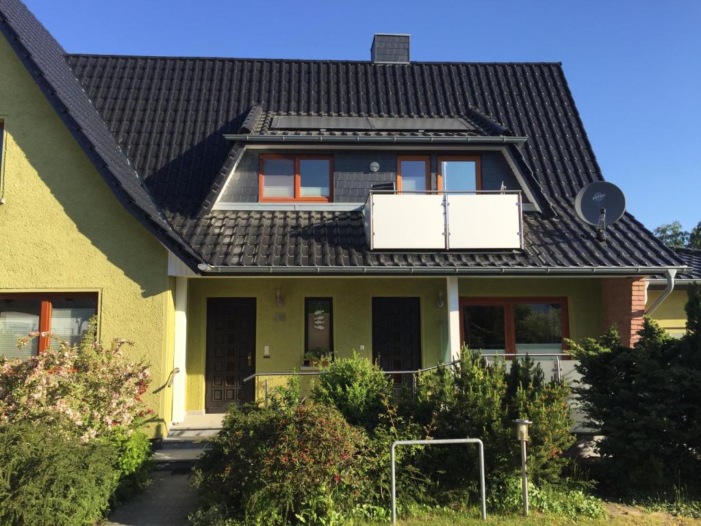 ツィングストにあるBei Petrus unterm Dachの黒屋根の黄色い家