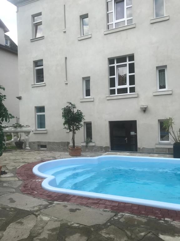 una grande piscina di fronte a un edificio di Pension Chevermeto a Chemnitz