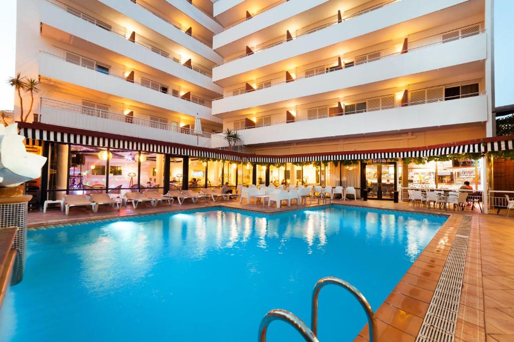 una gran piscina en un hotel con mesas y sillas en Hotel Xaine Park, en Lloret de Mar