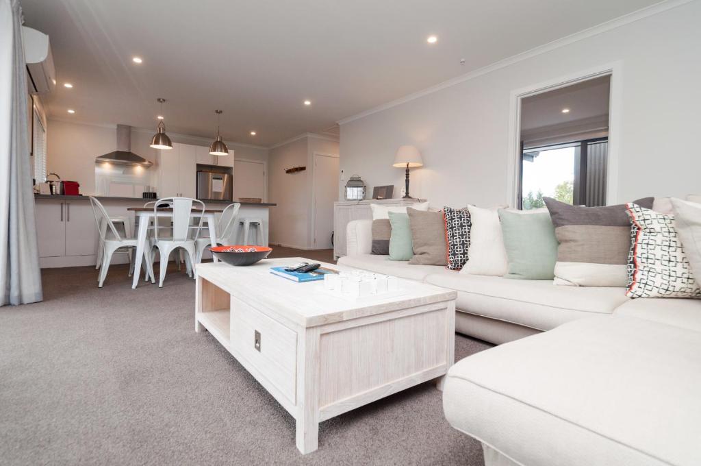 un soggiorno con divano bianco e tavolo di Luxury Rata Apartment - A a Twizel