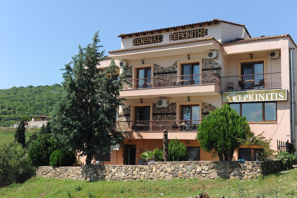 ein Gebäude auf einem Hügel mit Bäumen davor in der Unterkunft Guesthouse Kerkinitis in Lithótopos