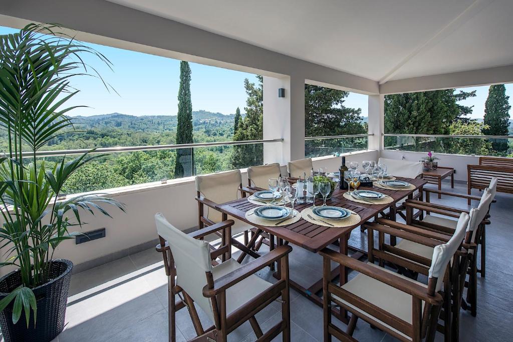 a dining room with a table and chairs and large windows at Gem Villa in Viros Corfu in Virós
