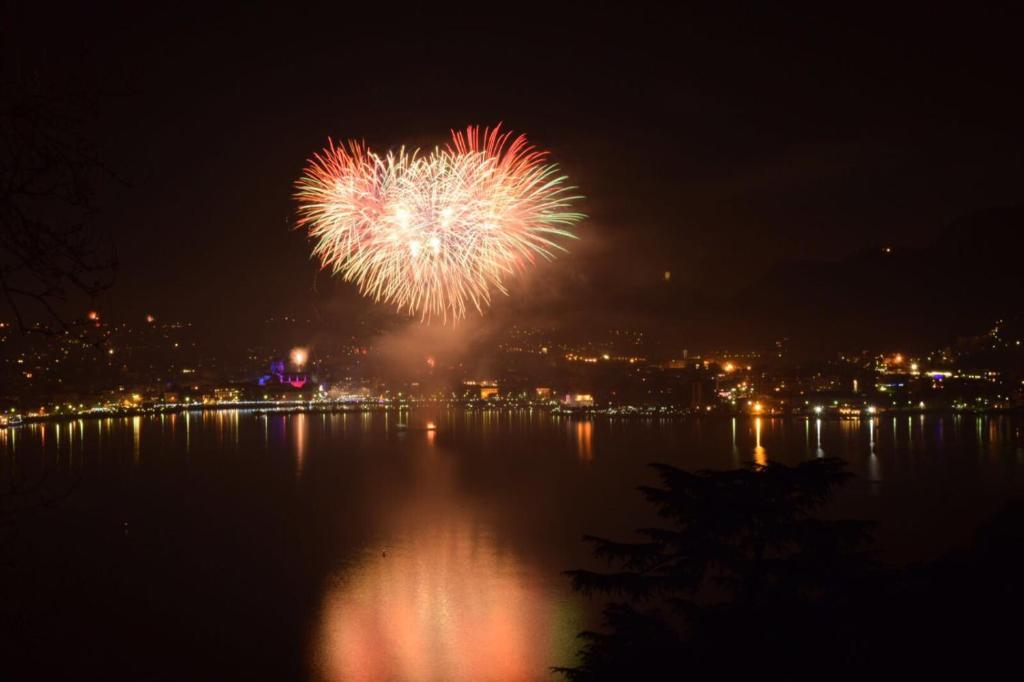 a firework display over a body of water at night at Como Luxury Rooms in Como