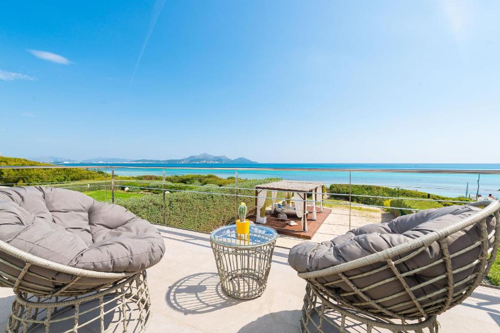 two chairs sitting on a patio overlooking the ocean at Sa Platja in Playa de Muro