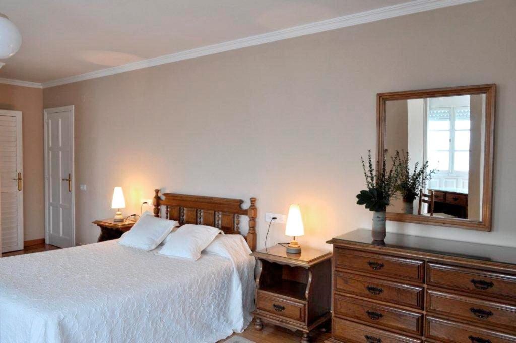 a bedroom with a bed and a mirror and a dresser at Cantábrico Fonsagrada in Fonsagrada