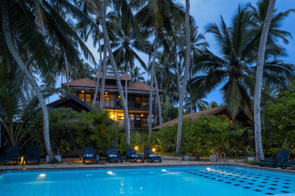 a resort with a swimming pool in front of a house at Seven Turtles in Tangalle
