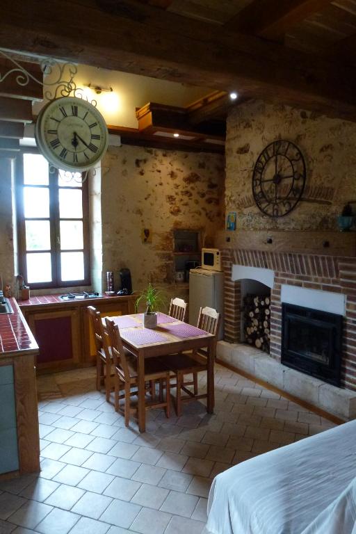 a kitchen and dining room with a table and a fireplace at Les Gîtes de l&#39;Orta in Saint-Jean-dʼEyraud