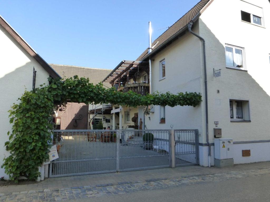 a white building with a fence and an ivy growing on it at Ferienwohnung Wendt in Wersau