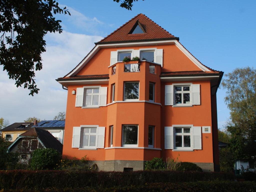 una casa naranja con techo de gambrel en Blum Ferienwohnung, en Constanza