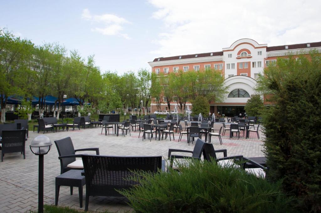 un grupo de mesas y sillas en un patio en Atyrau Dastan Hotel, en Atyraū