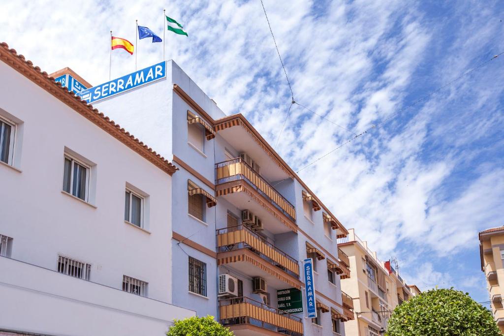 un hotel con dos banderas en la parte superior de un edificio en Serramar, en Benalmádena