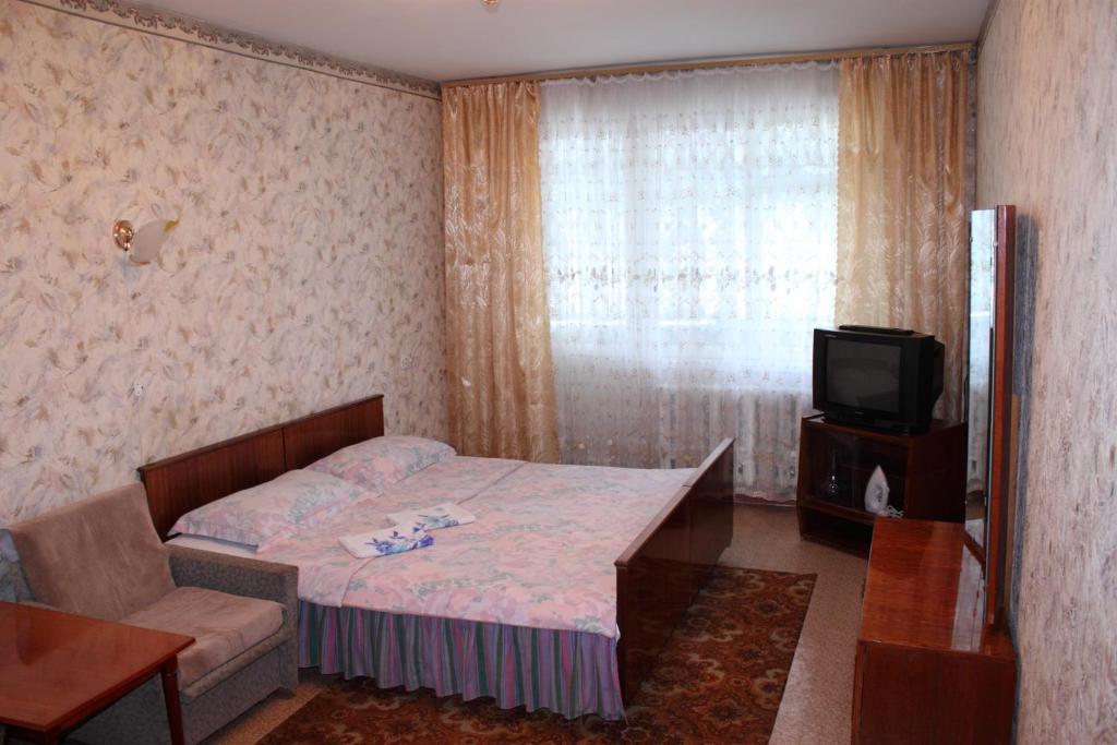 a small bedroom with a bed and a tv at Prime Home 3 in Chernihiv