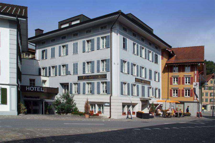 um grande edifício branco no lado de uma rua em Hotel Metzgern em Sarnen