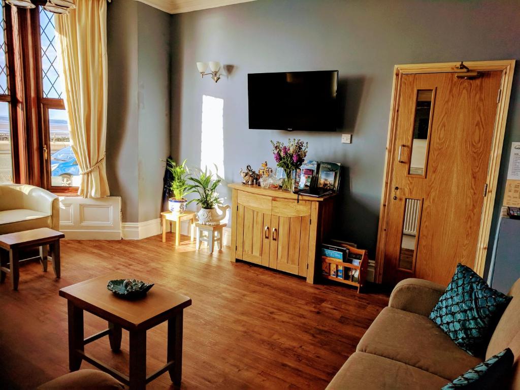 a living room with a couch and a flat screen tv at Craigwell in Morecambe