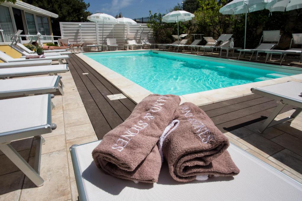 een handdoek op een tafel naast een zwembad bij Hotel Villa Serena in Castellammare di Stabia