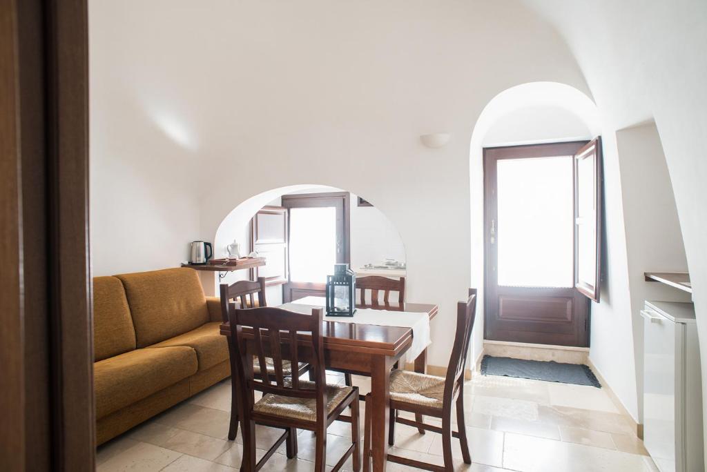 een woonkamer met een tafel en een bank bij Trullidea in Alberobello