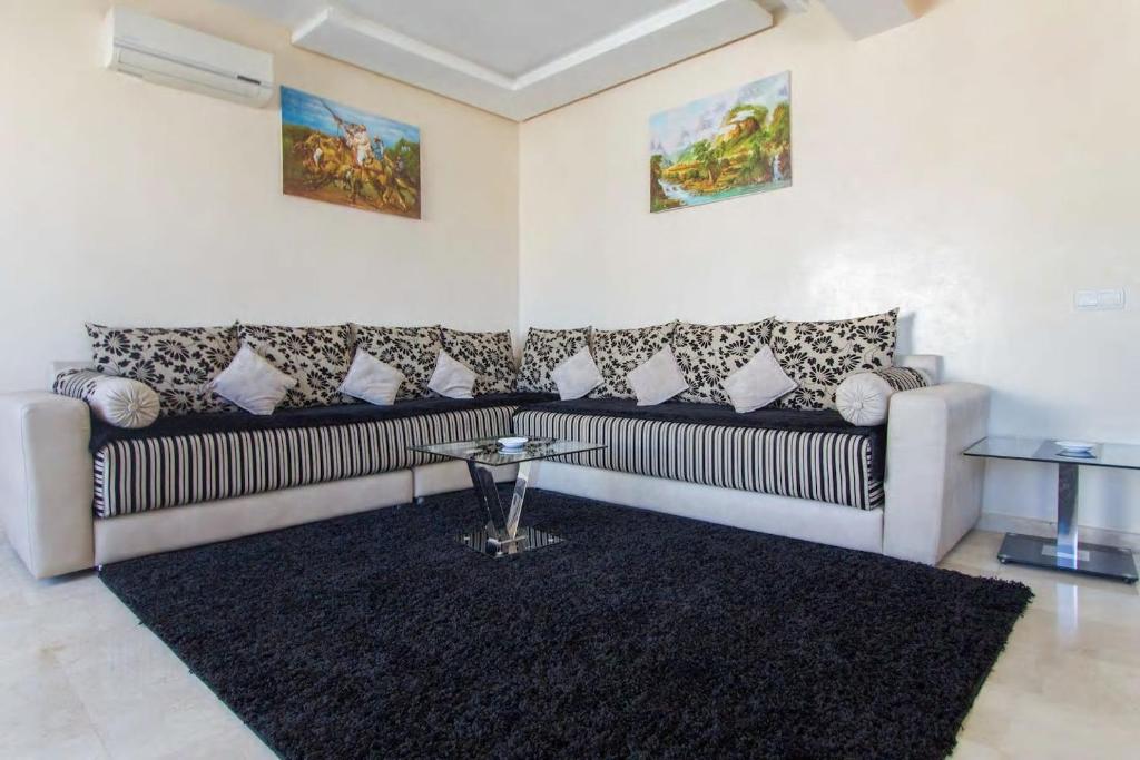 a living room with a couch and a rug at Res Mario 3 Lovely Apartment With Balcony & Sea View Free Wifi in Casablanca