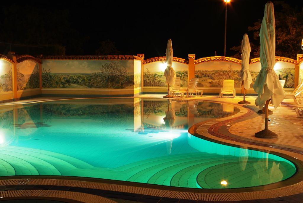 una piscina notturna con luci di Hotel Villa Letan a Fažana