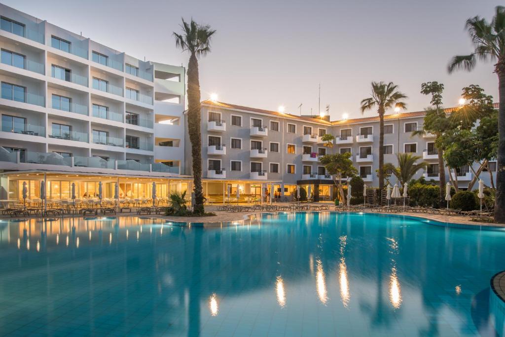 プロタラスにあるNarcissos Waterpark Resortの大きなスイミングプールが建物の前にあるホテル