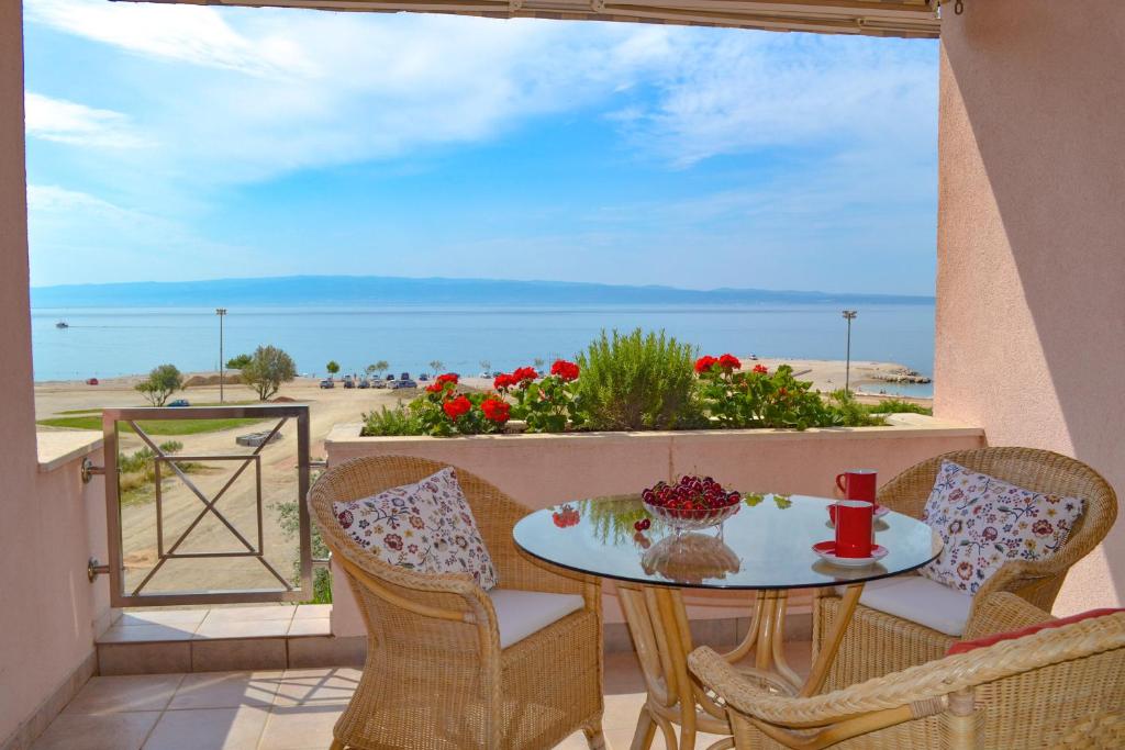 a table on a balcony with a view of the ocean at Apartment Sunny in Split