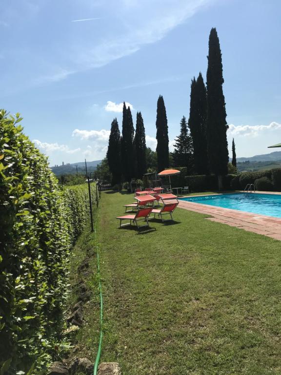 a row of picnic tables next to a swimming pool at Podere Remignoli in San Gimignano