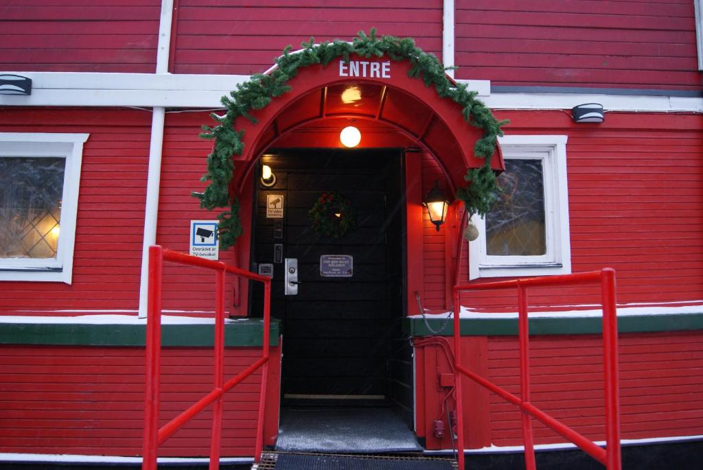an entrance to a red building with a christmasreath at Den Röda Båten in Stockholm