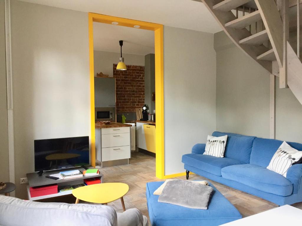 a living room with a blue couch and a tv at AMPELHAUS® in Oranienbaum-Wörlitz