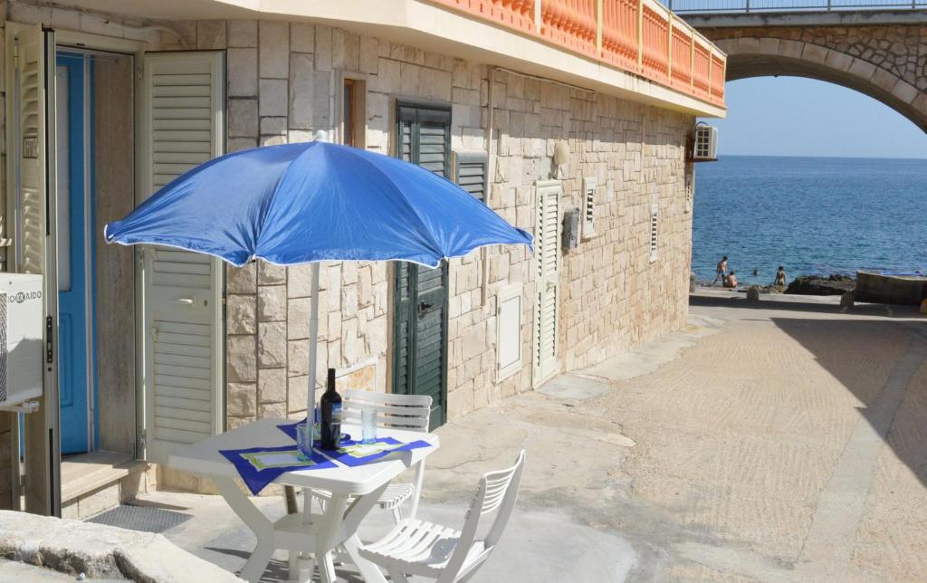 レウカにあるDimora del Marinaioの青い傘付きのテーブルと椅子
