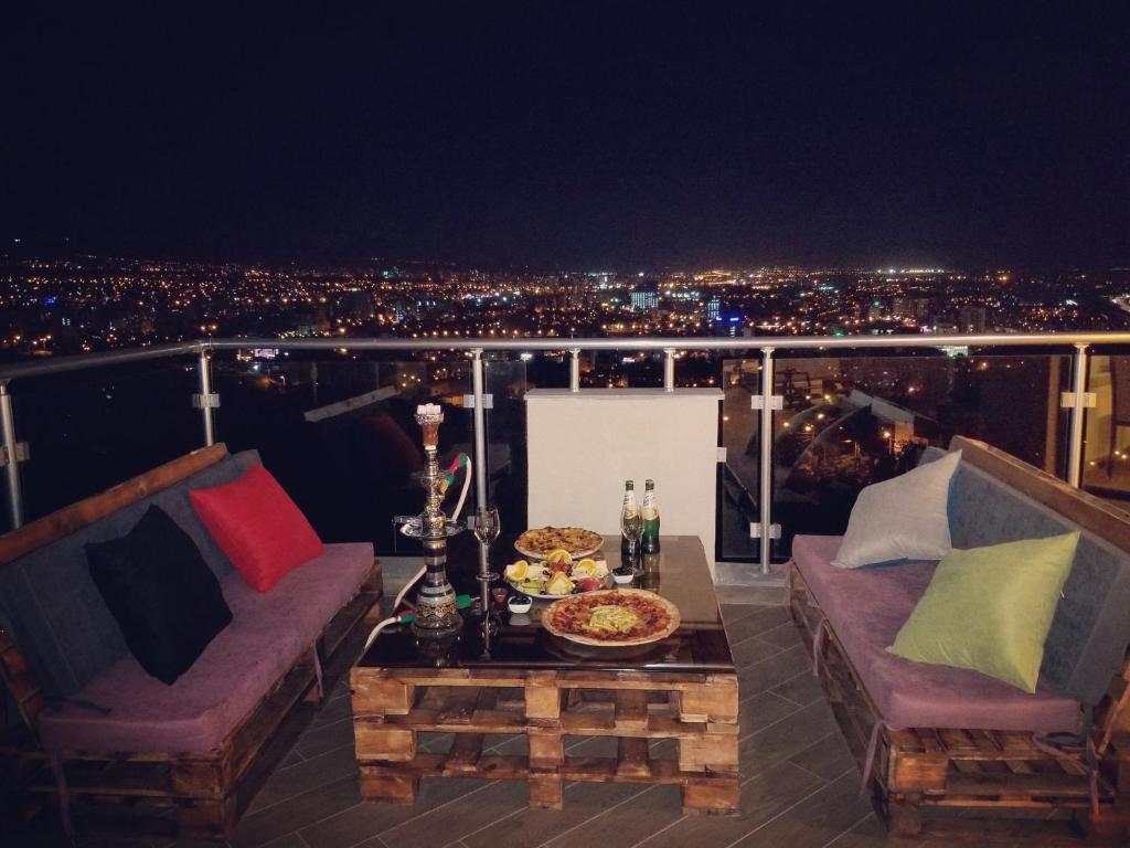 a room with two couches and a table on a balcony at Hotel King Tom in Tbilisi City