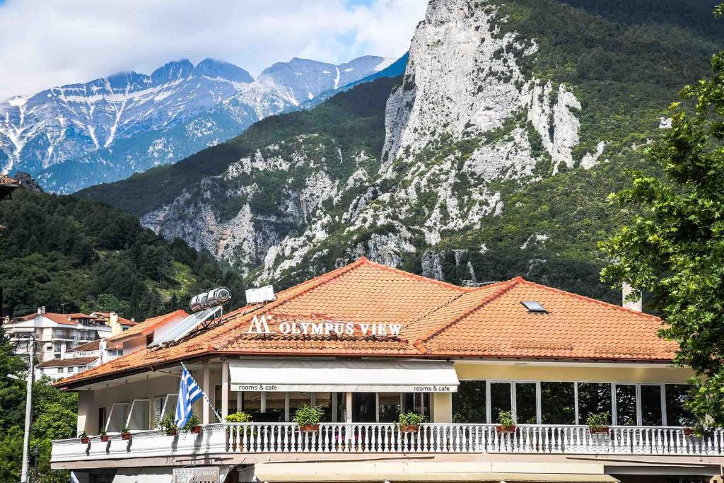 un bâtiment avec une montagne en arrière-plan dans l'établissement Olympus View Rooms Sauna & Spa, à Litochoro