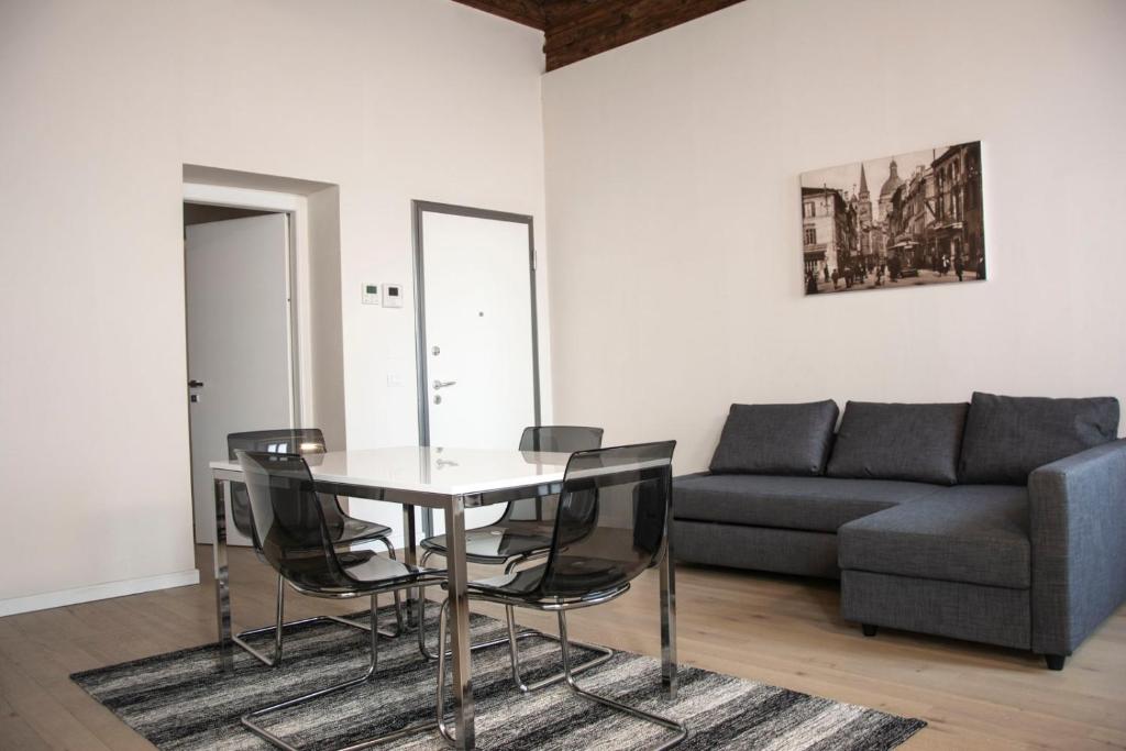 uma sala de estar com uma mesa e cadeiras e um sofá em Residenza La Torre em Mantova