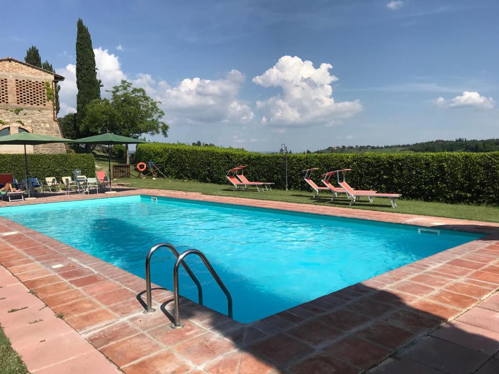 a swimming pool with two lawn chairs at Podere Remignoli in San Gimignano