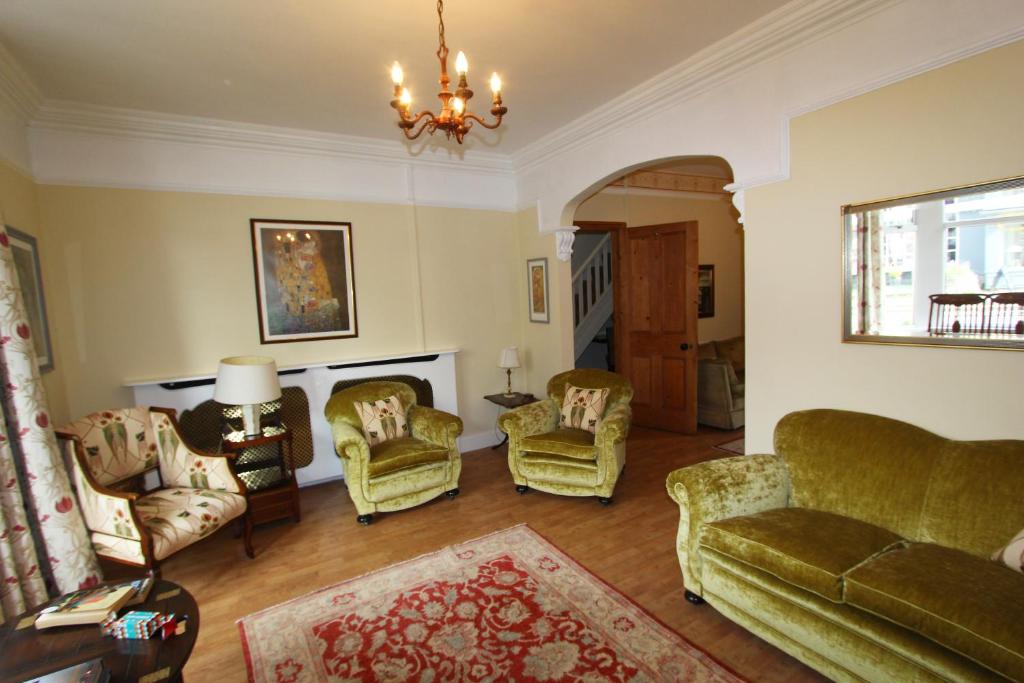 a living room with chairs and a chandelier at 81 Eastgate in Cowbridge