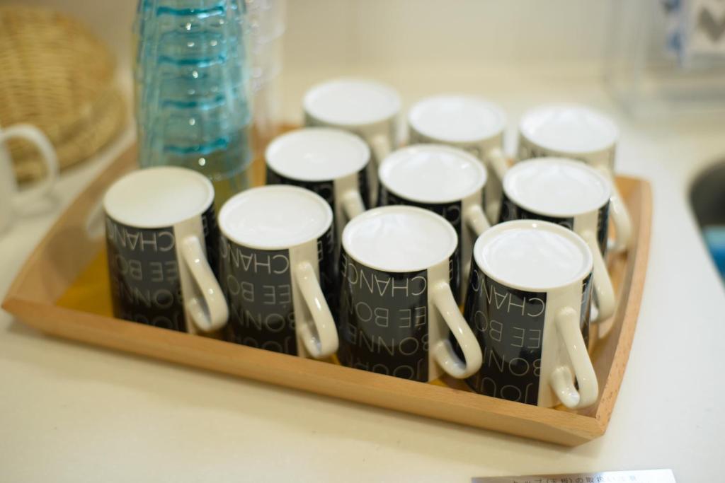 a group of toothbrushes in a wooden holder on a counter at Guesthouse Kintoto in Kanazawa