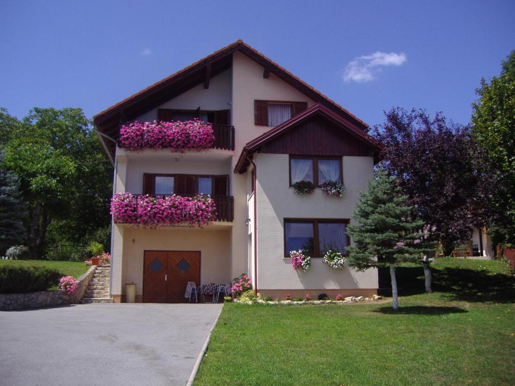 une maison avec des fleurs sur les balcons dans l'établissement Guesthouse Hodak, à Selište Drežničko