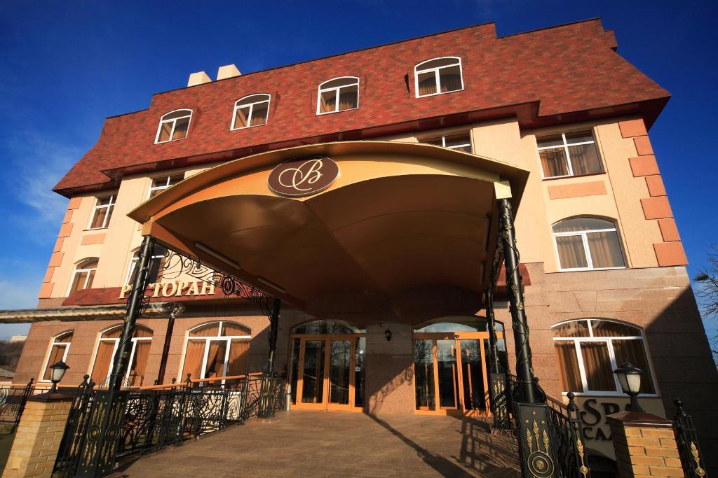 ein Gebäude mit einem Torbogen davor in der Unterkunft Victoria Hotel in Kharkov