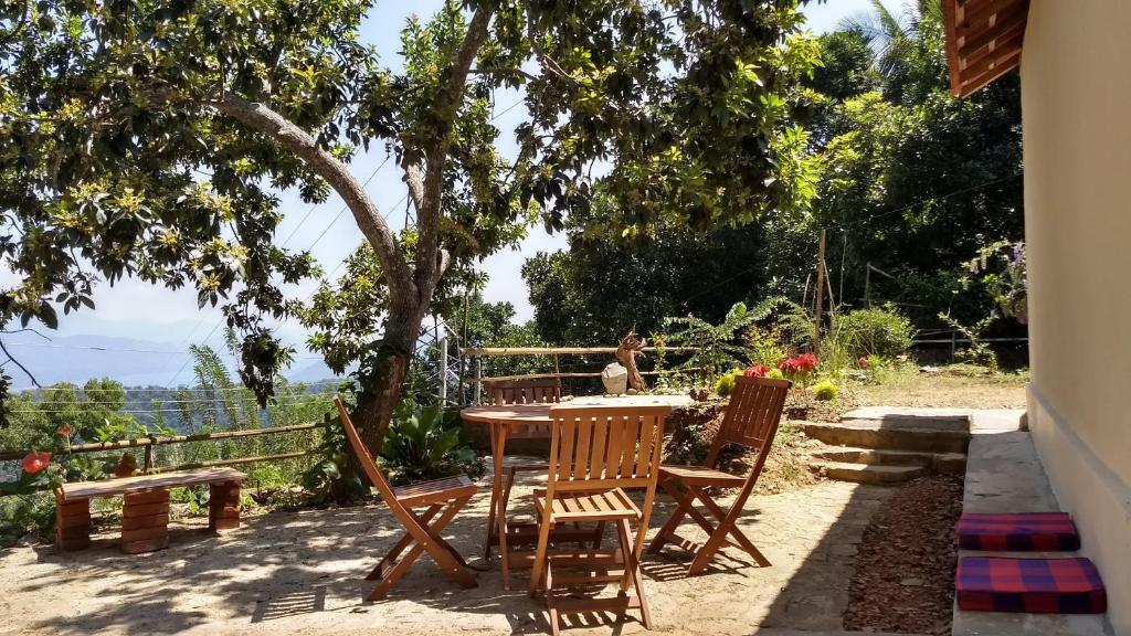una mesa y sillas en un patio bajo un árbol en The Pepper Cottage, en Gomagoda