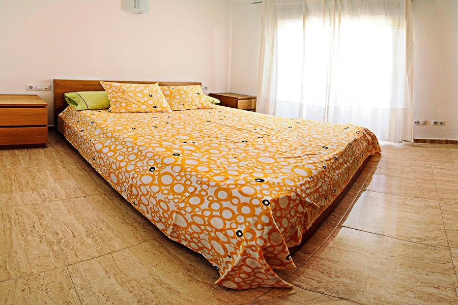 モライラにあるApartamento Moraira Centro a 200m de la playaのベッドルーム1室(大型ベッド1台、オレンジ色の掛け布団付)