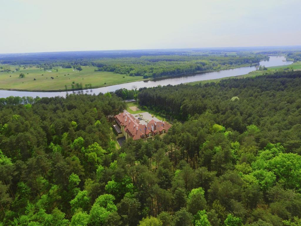 eine Luftansicht eines Hauses im Wald neben einem Fluss in der Unterkunft Hotel Drohicki in Drohiczyn