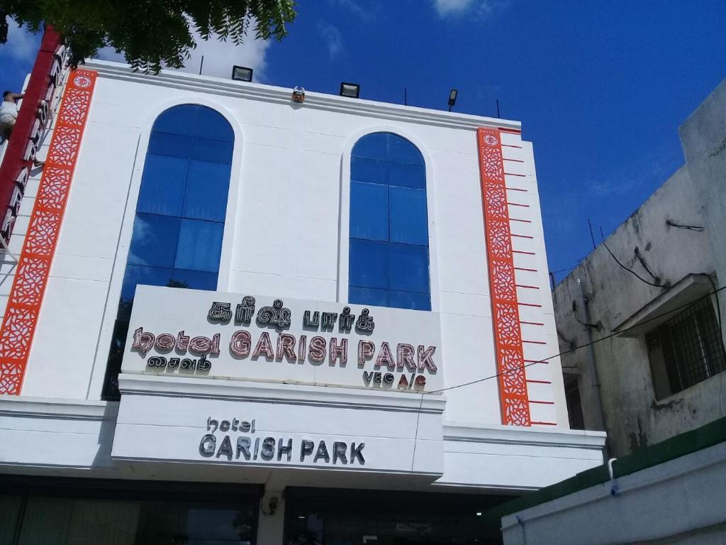 a white building with a canadian park sign on it at Hotel GARISHPARK in Rāmanāthapuram