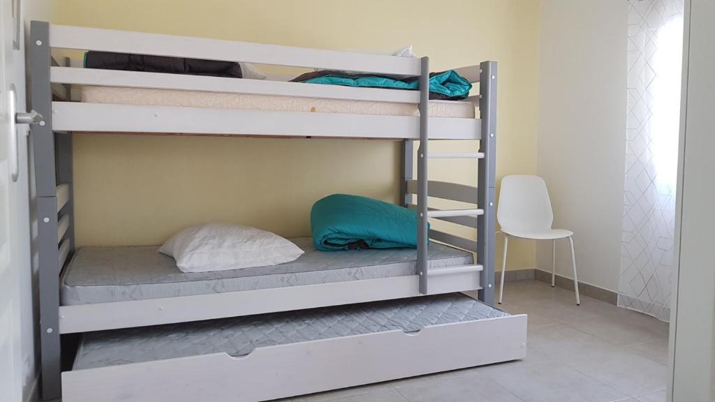 two bunk beds in a room with a chair at Boost Your Immo La Courtaude T3 N in Six-Fours-les-Plages