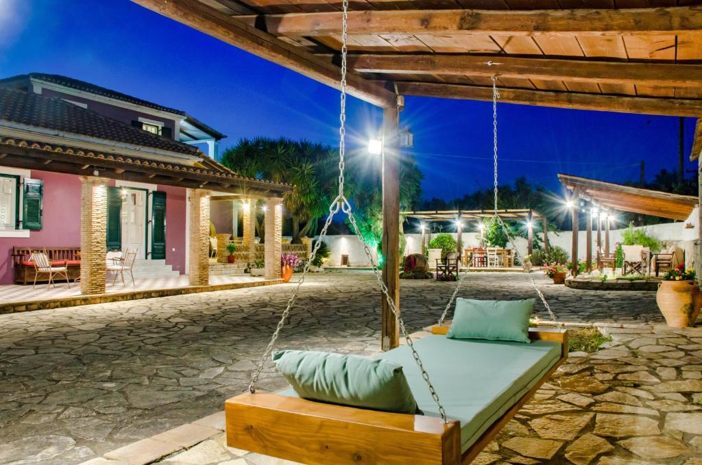 a swing in the courtyard of a house at night at Ermioni Villa in Tsilivi