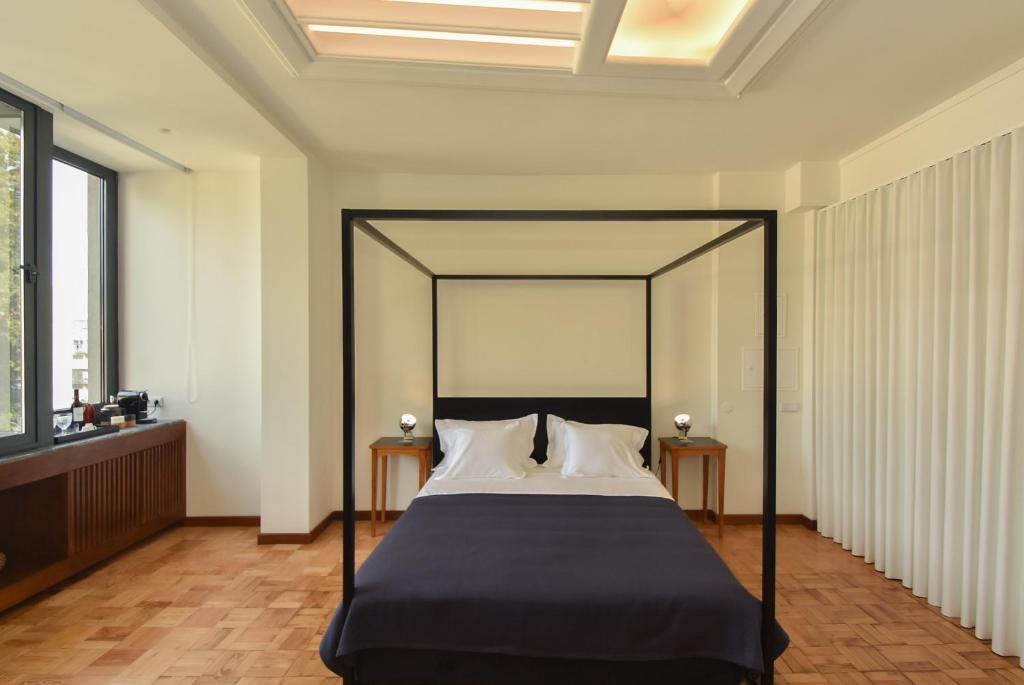 a bedroom with a bed with a black canopy at Republica 157 Guest House in Porto