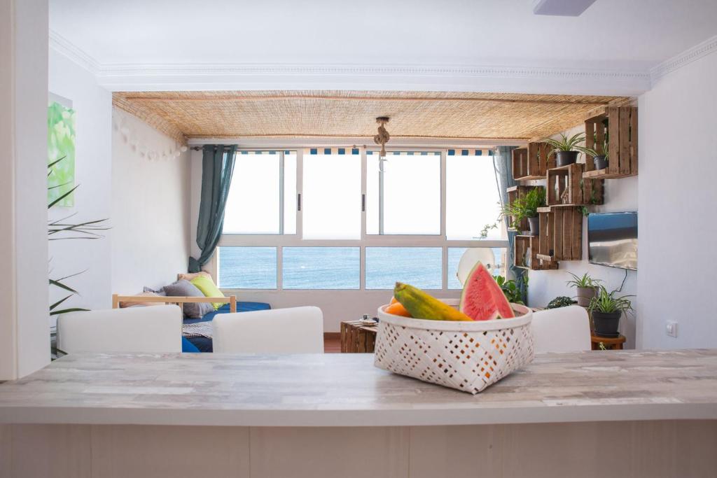 una cocina con mesa y un tazón de sandía en Oasis Alicante, en Alicante