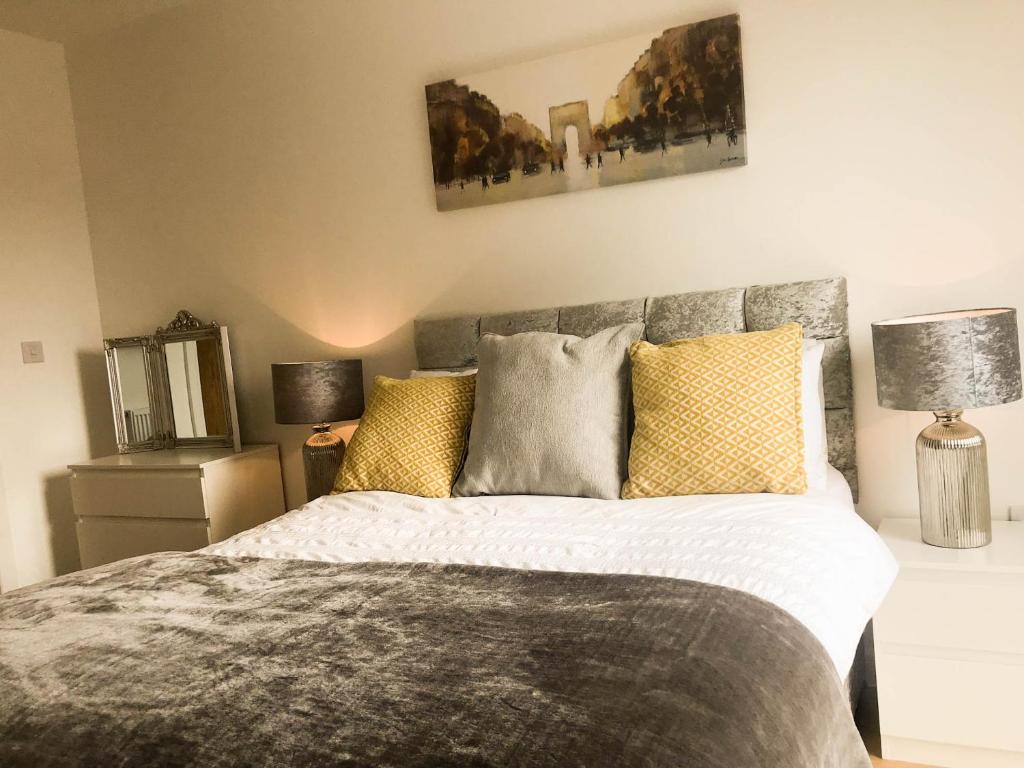 a bedroom with a large bed with yellow pillows at City Centre Apartment in Portsmouth