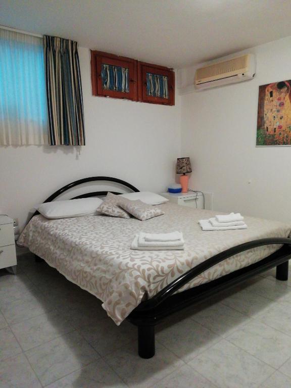 a bedroom with a bed with two towels on it at Viniola Apartment in Quartu SantʼElena