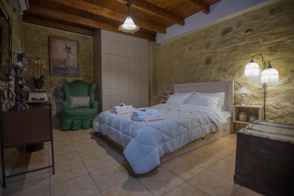 sypialnia z dużym łóżkiem i zielonym krzesłem w obiekcie Villa Kamelia-Renovated old house-South Crete w mieście Galiá