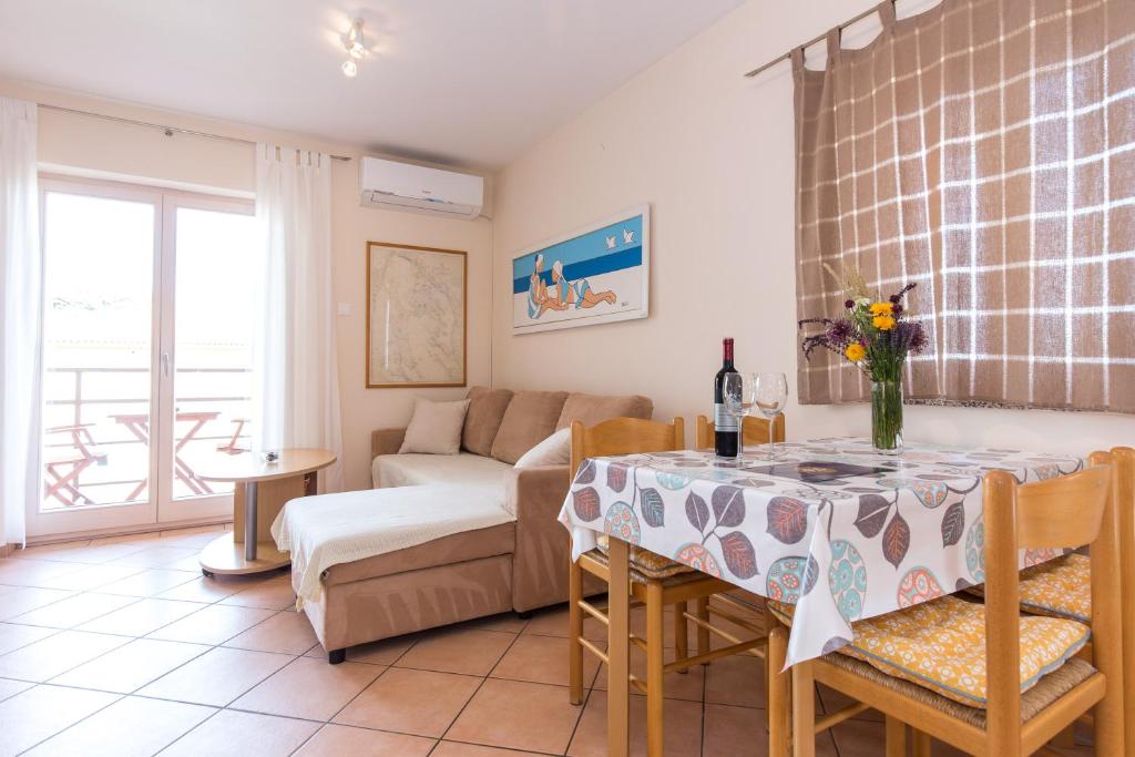 een woonkamer met een tafel en een bank bij Apartments Marta in Krk
